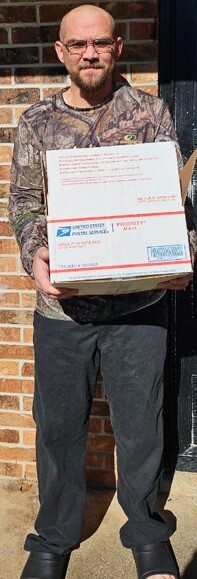 A man holding a box from the Christmas food giveaway.